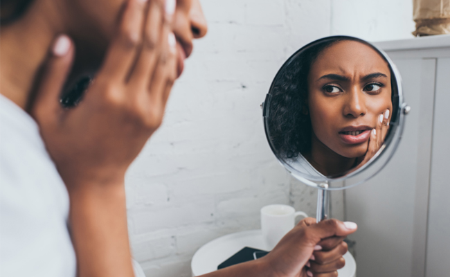 Woman examining teeth in mirror, dental health and hygiene concept for family dentistry.