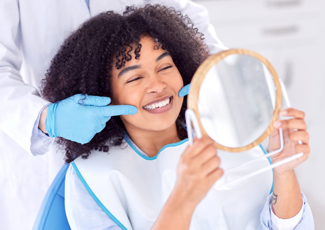 Woman holding mirror and cleaning cloth smiling at dental office