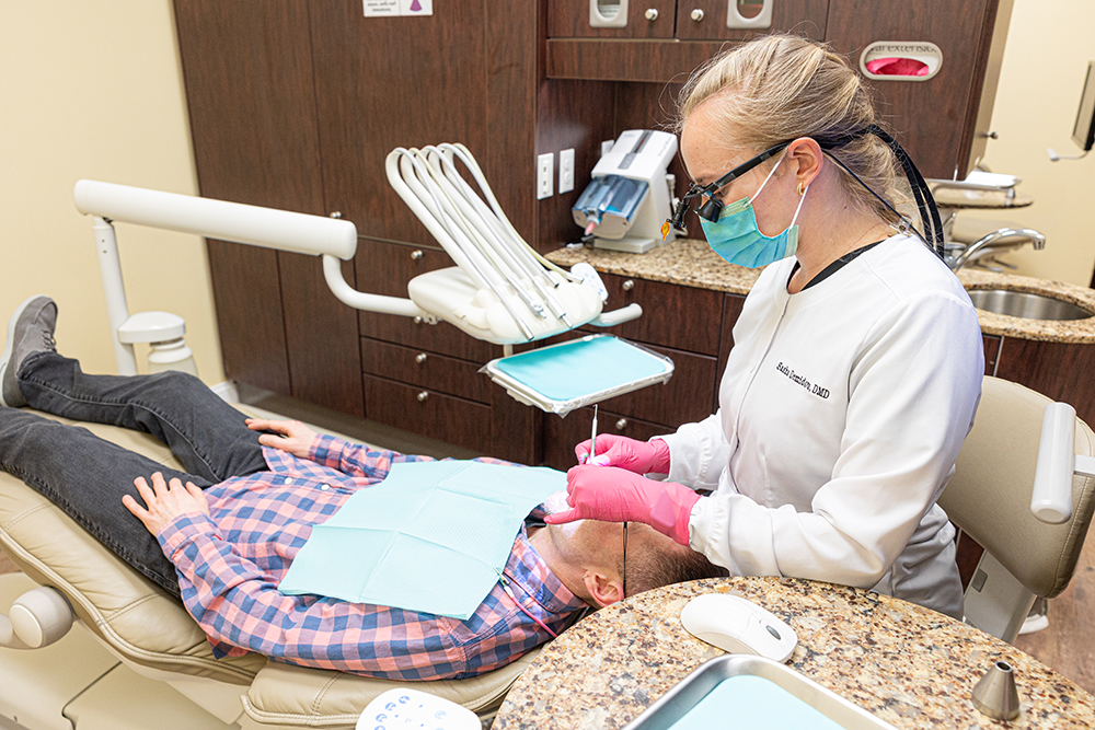 Dentist examining patient in dental chair at Fletcher Family Dentistry office.